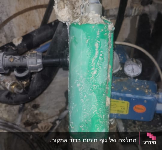 צינור ירוק עם הצטברות אבנית על דוד שמש